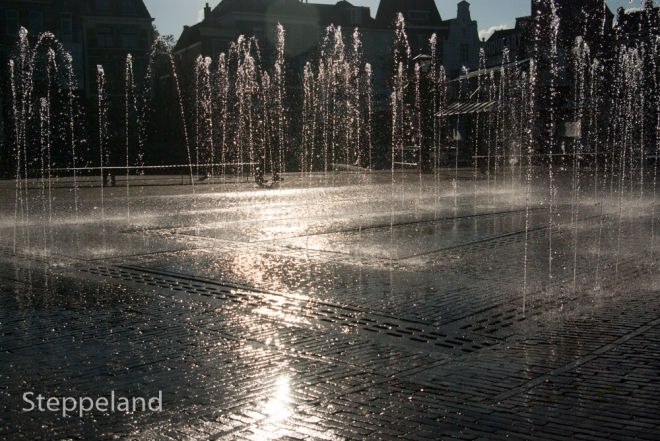 Sunlit fountain with trail of light